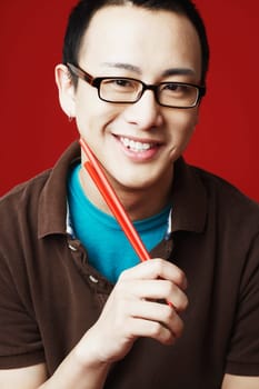 Portrait of a young man holding chopsticks
