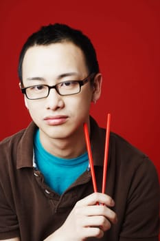Portrait of a young man holding chopsticks