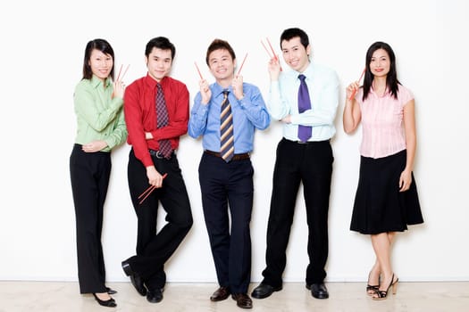 Portrait of five business executives holding chopsticks