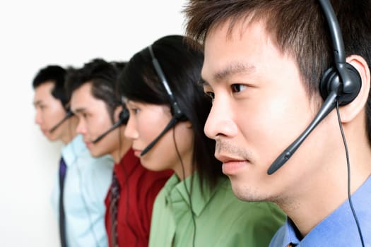 Four customer service representatives talking on headsets
