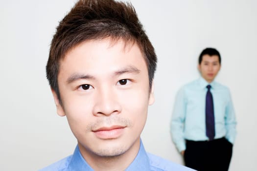 Portrait of a businessman with another standing behind him