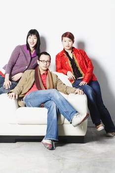 Portrait of a young man sitting with two young women