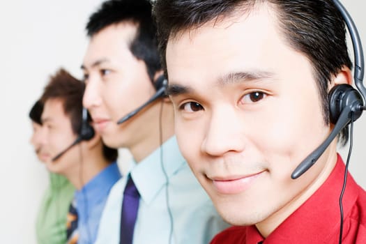 Four customer service representatives talking on headsets