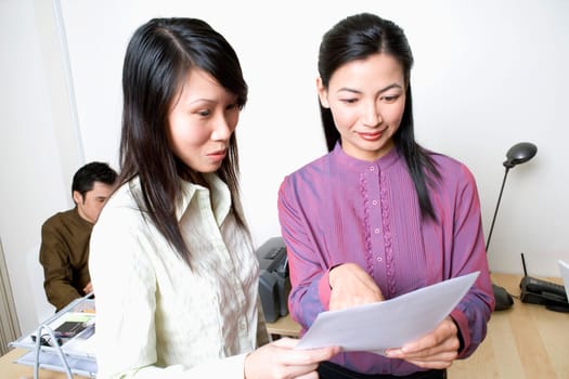Two businesswomen reading a document