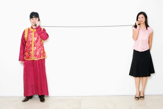 Mid adult woman and a young man talking on telephones