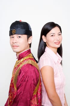 Portrait of a young man and a mid adult woman standing back to back