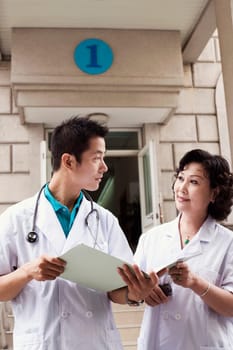Male doctor and a female doctor discussing a report