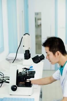 Side profile of a doctor looking into a microscope