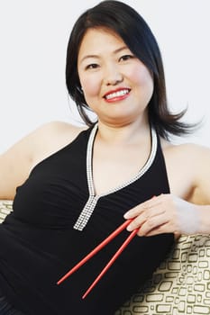 Portrait of a mid adult woman holding chopsticks