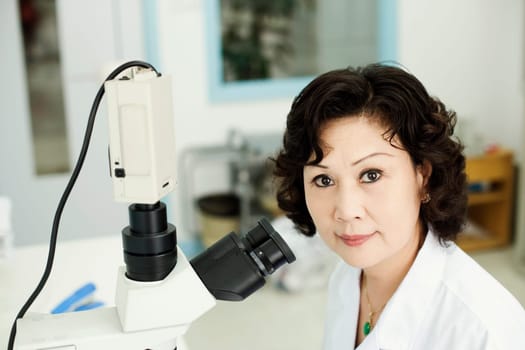 Portrait of a female doctor in front of a microscope