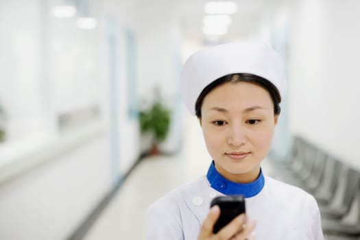 Close-up of a female nurse operating a mobile phone
