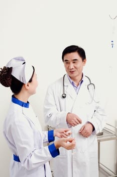 Male doctor talking to a female nurse