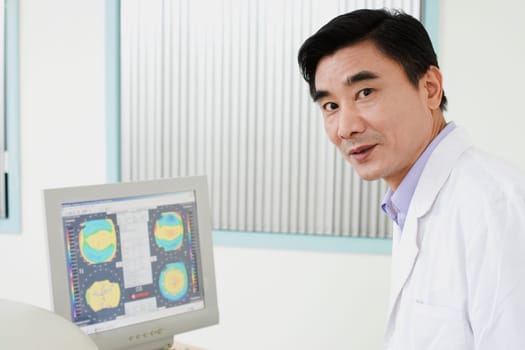 Portrait of a male doctor in front of a computer monitor