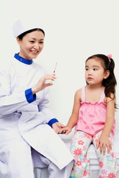 Female nurse holding a girl and a syringe
