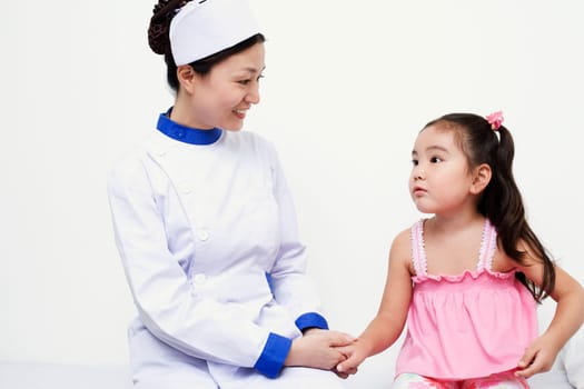 Close-up of a female nurse and a girl child holding hands