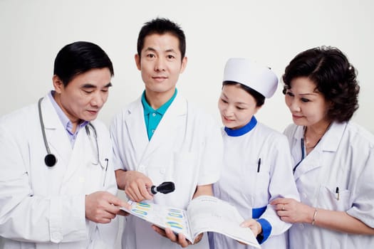 Two male doctors and a female nurse looking at a report