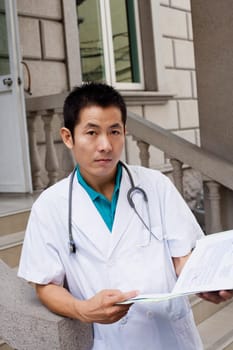Portrait of a male doctor holding a report
