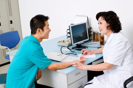 Side profile of a female doctor taking a patientŽs pulse