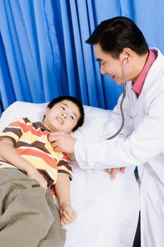 Side profile of a male doctor examining a boy with a stethoscope