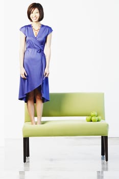 Portrait of a young woman standing on a couch