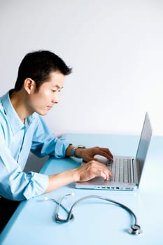 Side profile of a doctor operating a laptop