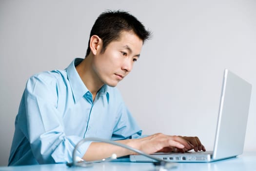 Close-up of a doctor operating a laptop
