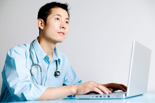 Close-up of a doctor operating a laptop
