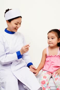 Female nurse holding a syringe with a girl beside her