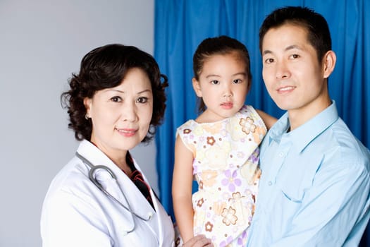 Portrait of a female doctor a girl child and a young man smiling