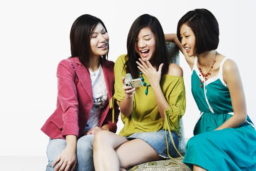 Three young women looking at a digital camera