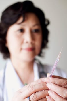 Close-up of a female doctor holding a syringe