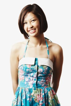 Portrait of a young woman standing with her hands behind her back