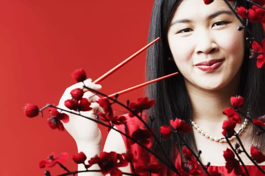 Portrait of a young woman holding chopsticks