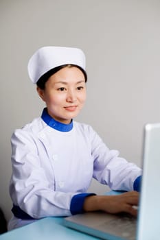 Close-up of a female nurse working on a laptop