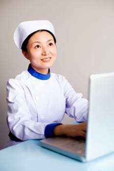 Close-up of a female nurse working on a laptop