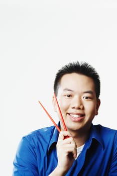 Portrait of a young man holding chopsticks