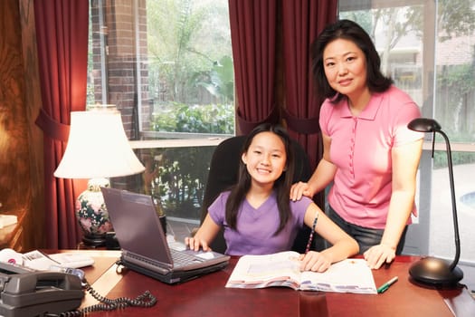 Portrait of a girl and her mother in front of a laptop