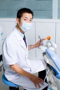 Portrait of a dentist sitting with medical equipment