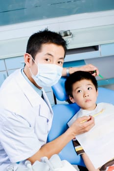 Portrait of a male dentist examining a boy