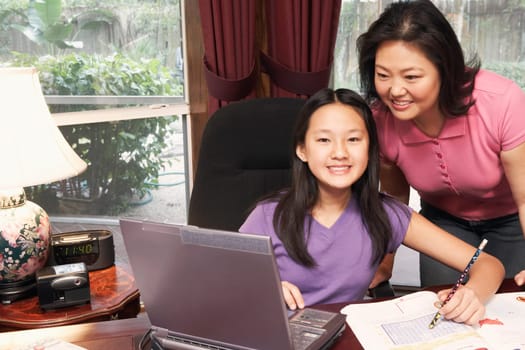 Portrait of a girl and her mother in front of a laptop