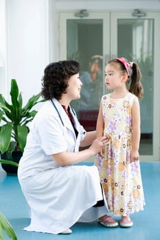 Side profile of a female doctor smiling with a girl standing beside her