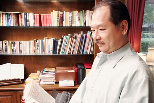 Side profile of a senior man reading a book