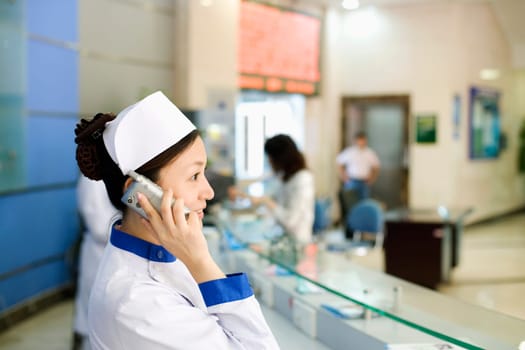 Side profile of a female nurse talking on the telephone