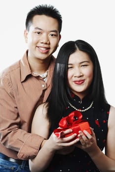 Portrait of a young couple holding a gift
