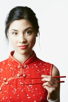 Portrait of a young woman holding chopsticks