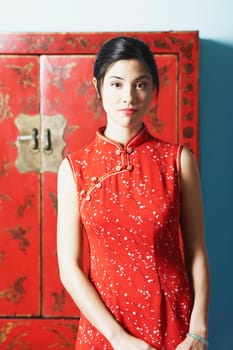 Portrait of a young woman standing in front of a cupboard