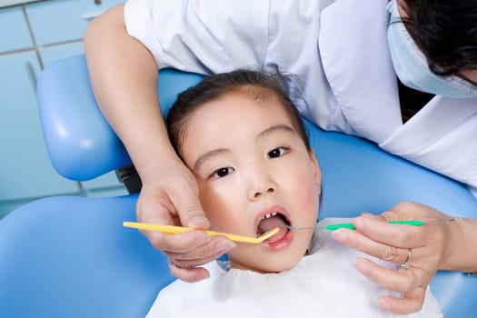 Close-up of a female dentist examining a girlŽs teeth