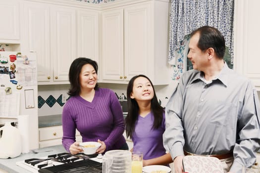 Close-up of a girl and her parents in the kitchen