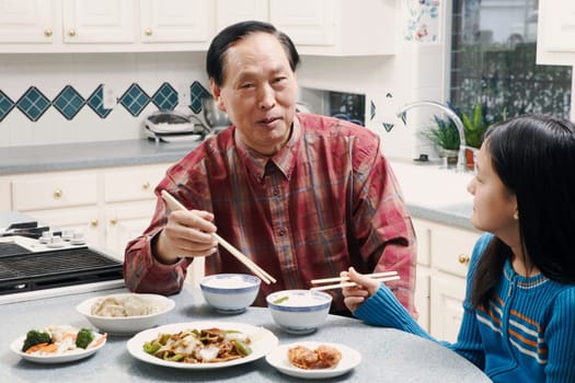 Grandfather and his granddaughter sitting at a table