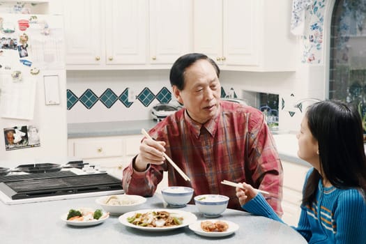 Grandfather and his granddaughter sitting at a table
